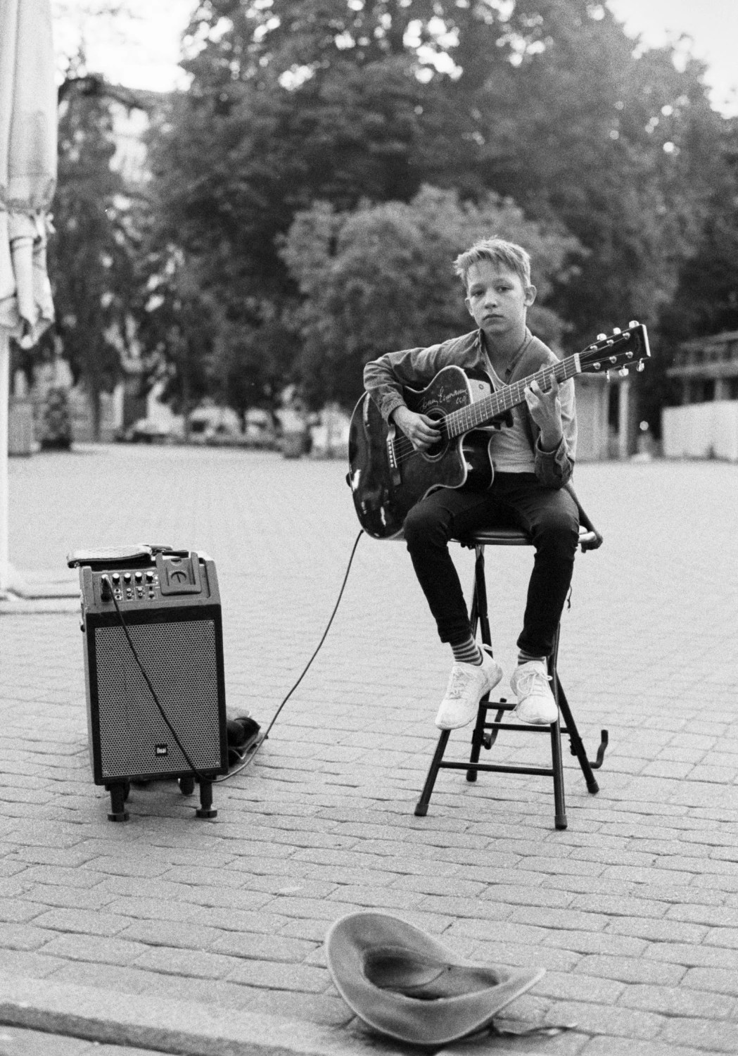 Kid playing music in the middle of Riga, charming look and great passion with talent