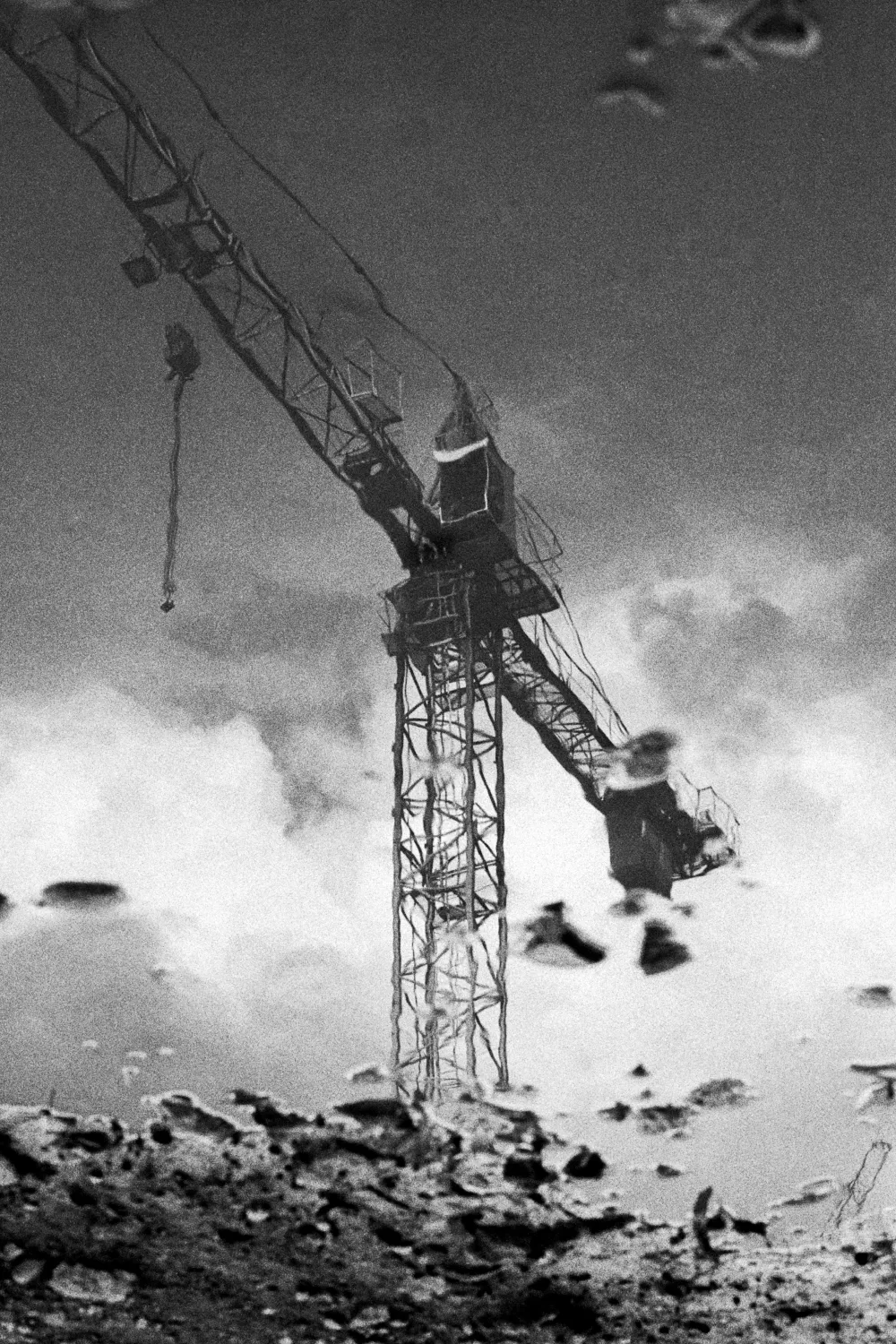 Construction crane reflection in the puddle.