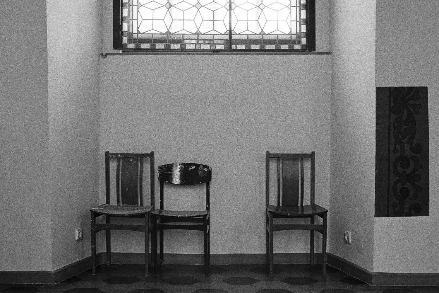 Three empty chairs. Two chairs are pushed together, one is from a distance.