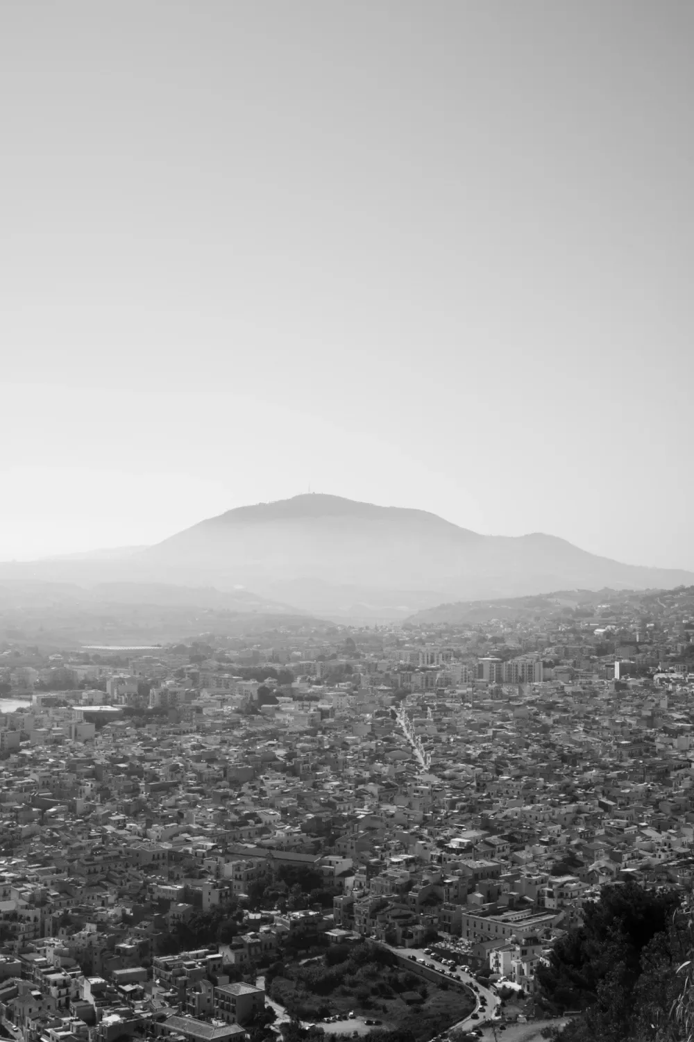 Endless city of Castellammare del Golfo with a far view of misty, humongous mountain.