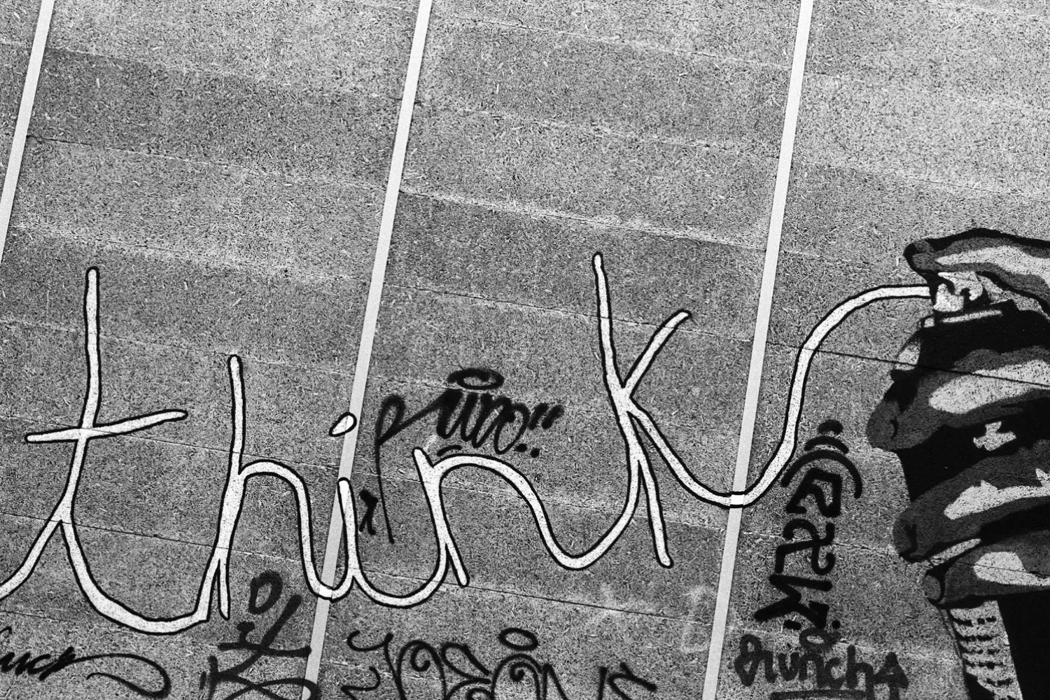 Graffiti with words "think" on the wall, and the words are coming from a spray can.